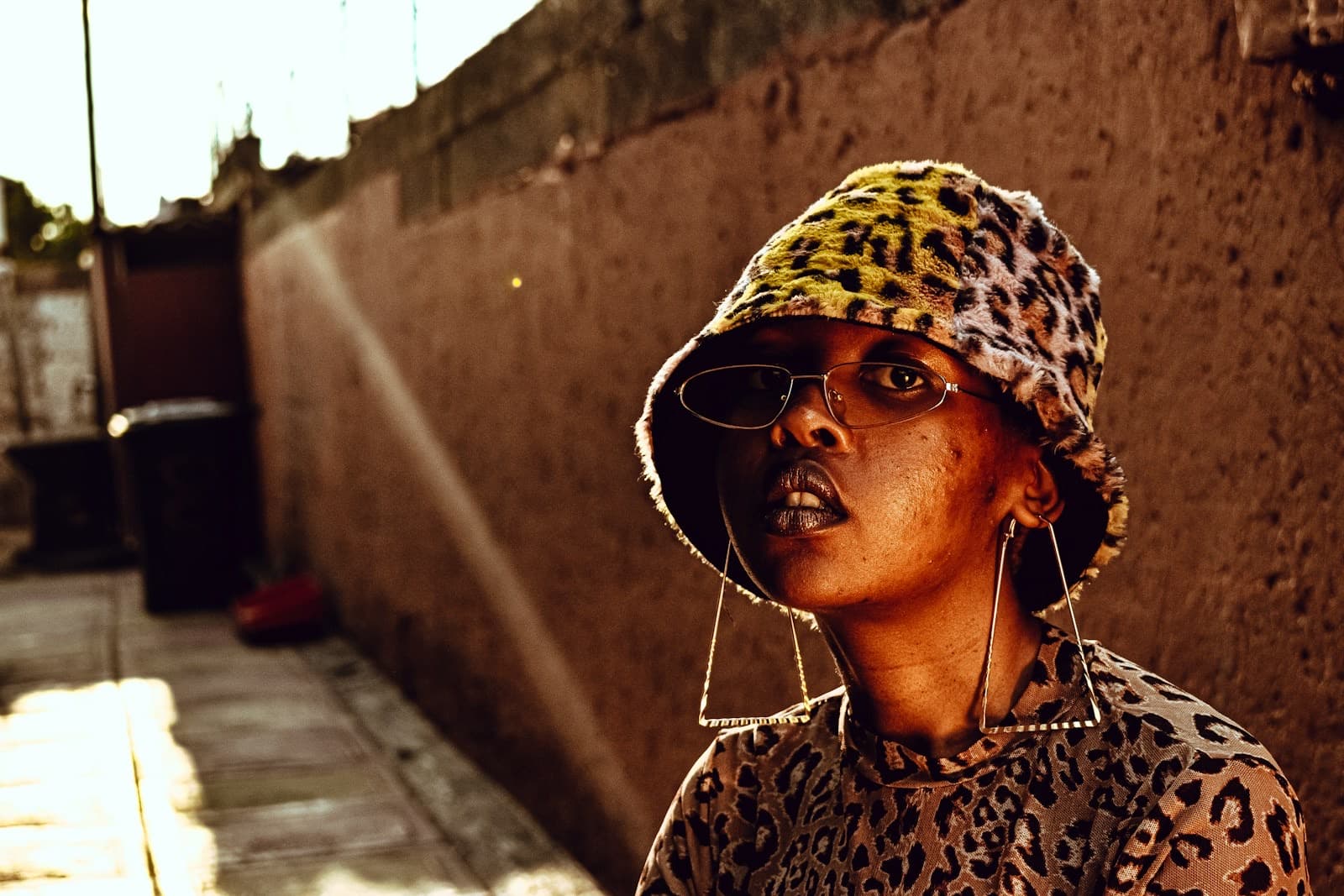 A woman in a leopard bucket hat in a Johannesburg lane
