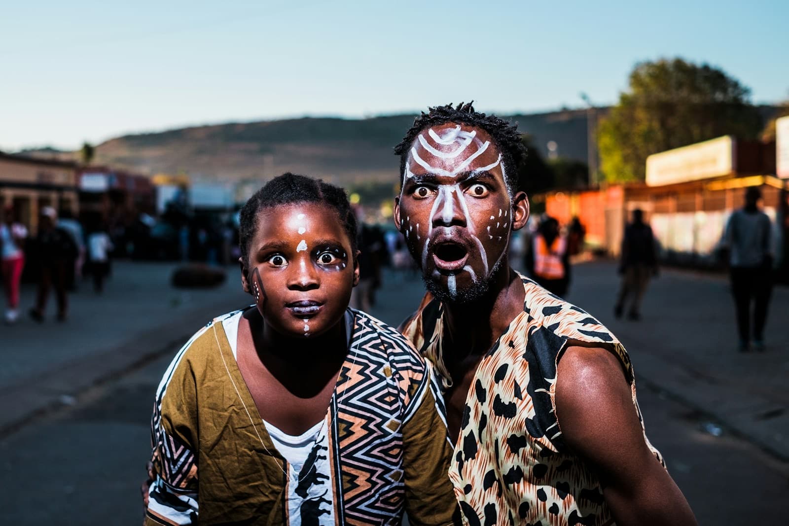 Two people in face paint on a street