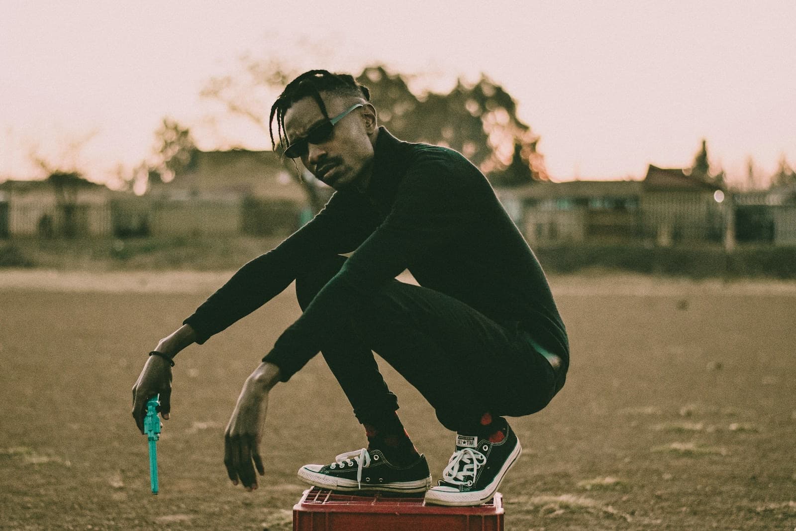 A man crouching on a red crate