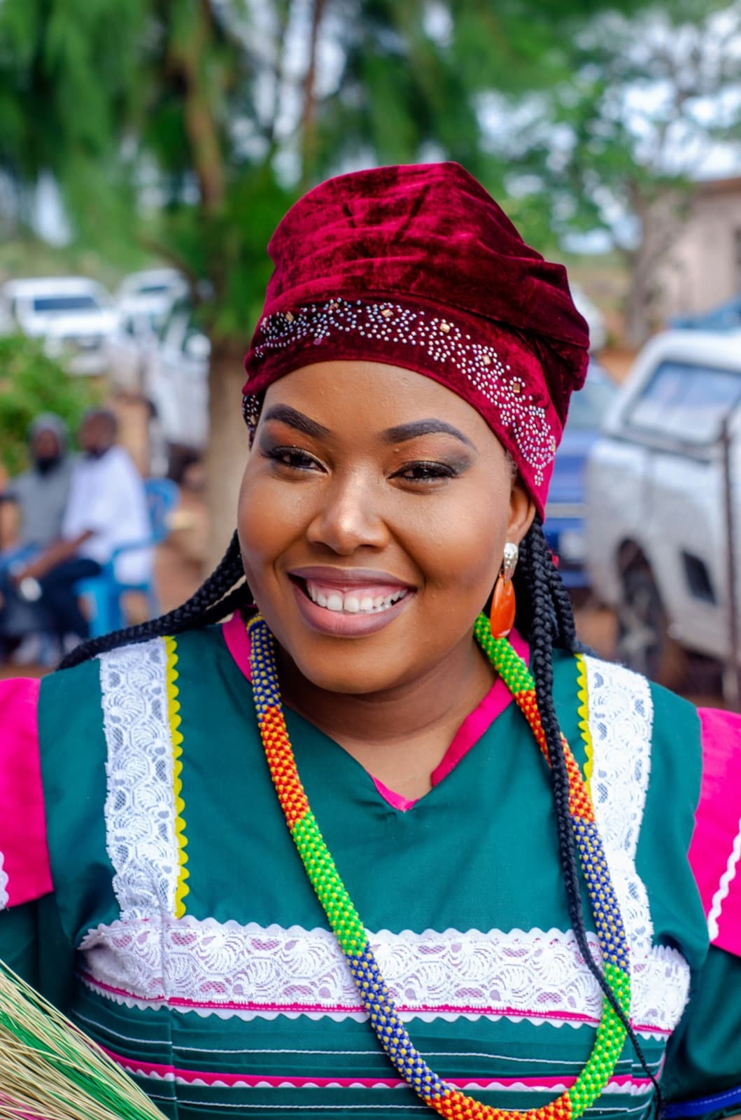 A woman in a red headwrap smiling